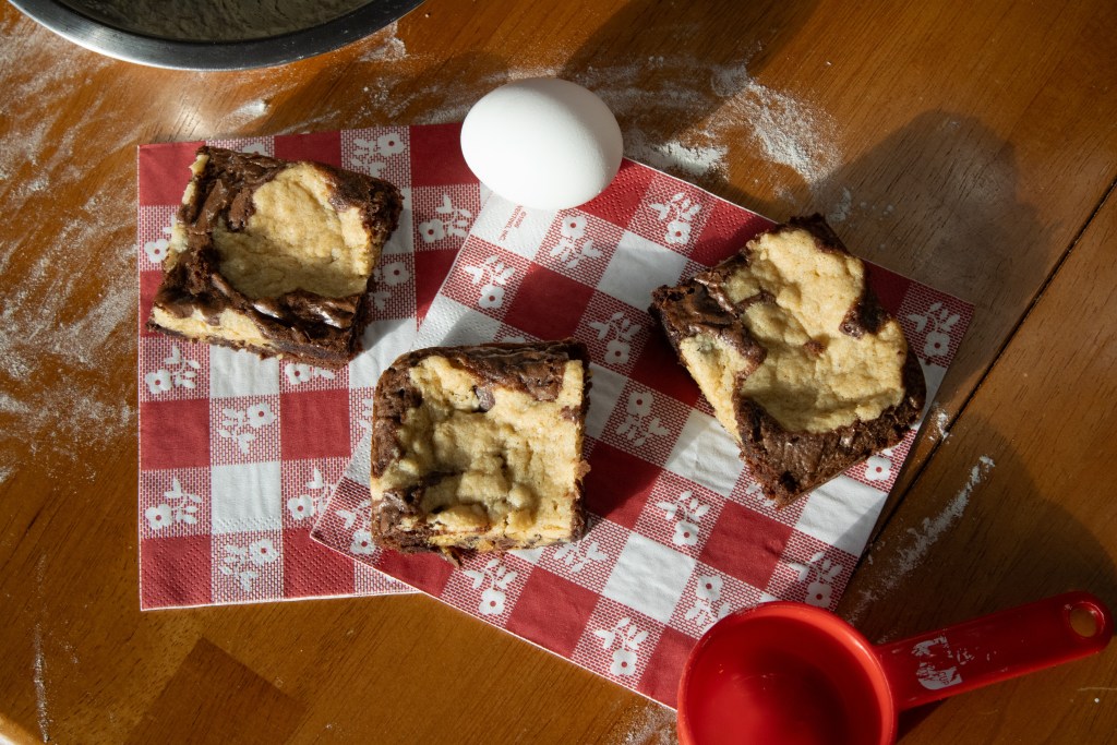 Overhead shot of brookies on checkered napkins with related ingredients around them